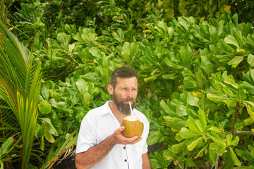Man Drinking Fresh Coconut Water in Tropical Nature