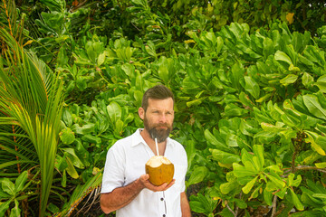 Man Drinking Fresh Coconut Water in Tropical Nature
