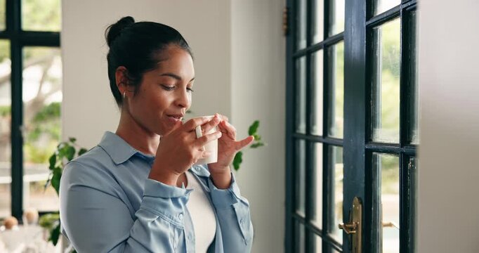 Happy, woman and thinking with coffee at glass door to start day, check weather and reflection. Smile, calm person and thoughtful with beverage in home for peaceful morning, daydreaming and fantasy