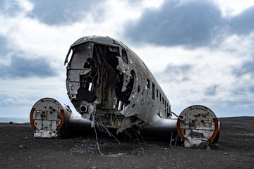 crashed and damaged airplane on black sand