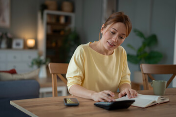Obraz premium Woman calculating home budget managing personal finances