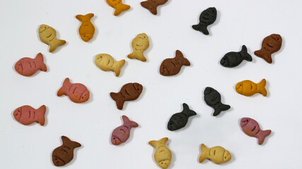 Salty biscuits in the shape of small colorful fish isolated on a white background. The concept of delicious and sweet biscuits.