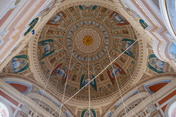 Naklejka premium Looking up at the richly decorated dome inside Ortakoy Mosque (Buyuk Mecidiye Camii) in Istanbul, Turkey, featuring Ottoman-Baroque stucco, painted panels and gilded detail