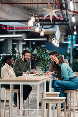 Diverse startup team collaborating on laptop during office meeting