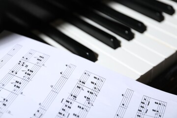 Fototapeta premium Closeup view of piano keys with notes. Musical instrument