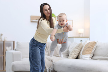 Fototapeta premium Mother playing with her cute baby boy at home