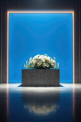White flowers in concrete planter on platform framed by glowing light reflected on dark floor
