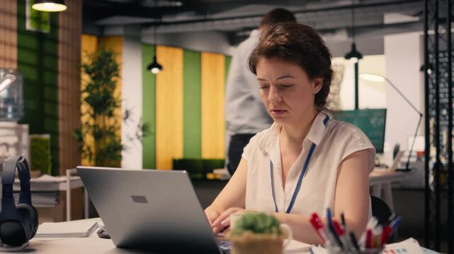 Anxious businesswoman under intense work pressure at office desk, drained and worried as deadlines approach. Ineffective and uncertain woman with excessive workload, low productivity.
