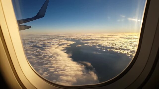 Airplane wing soaring above a vast expanse of f white clouds at sunrise