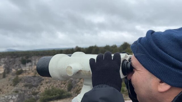 Hombre usando prism&aacute;ticos en mirador del Ca&ntilde;&oacute;n de R&iacute;o Lobos