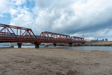 Obraz premium Iconic red iron railway bridge crossing the Shirakawa River in Kumamoto