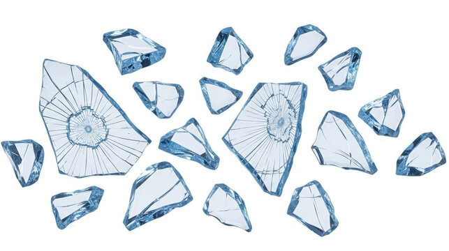 Numerous sharp edged shards of broken clear blue ice and glass are scattered across the frame reflecting light with a frosty sheen fragments frozen cold winter cracked textured