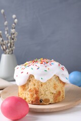 Delicious Easter cake, painted eggs and willow branches on white wooden table, closeup