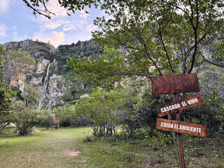 Panoramic view of El Vino Waterfall with a wooden sign in Dinira National Park, Venezuela - Ecotourism concept