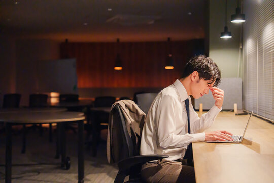 夜遅くまで残業をする若い男性スタッフ
