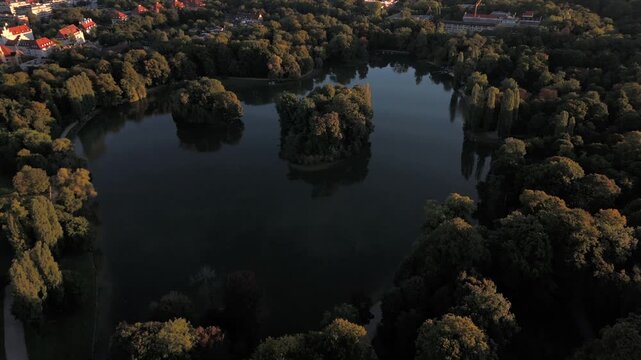 Aerial view of Kleinhesseloher See in English Garden, Munich, Germany. Bavarian landmark with artificial lake, islands, trees, meadow, Seehaus, Schwabing, Isar, Hirschau, culture, tourism and nature