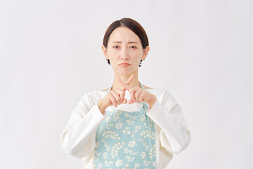 エプロンをつけた女性　ばつ印のジェスチャー　白背景