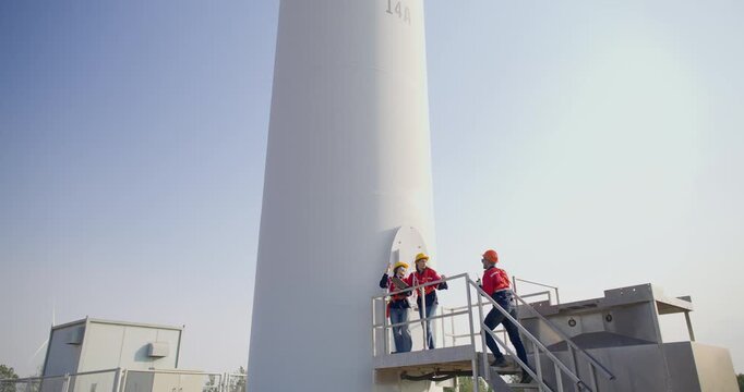 Wind turbine engineer and technician conduct field analysis with in wind farm. This scene underscores integration of technology and hands on fieldwork essential for advancing renewable energy projects