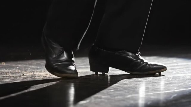 Close-up of a tap dancers feet performing on a stage with dramatic lighting, showcasing rhythmic movement and shadow play.