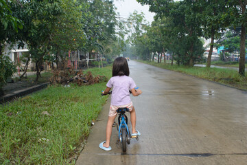 Little girl cycling on empty road