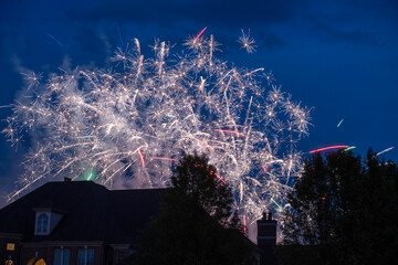 Fireworks Over Suburban Roofs Illuminate Night Sky During Celebration and Festive Display © dfriend150