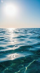 Obraz premium A bright sun illuminates clear blue water with gentle waves creating shimmering patterns perfect for a refreshing summer day at the beach ,refreshment ,daytime ,tranquil