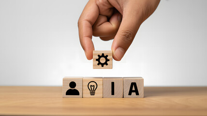 Hand placing a wooden block with a gear icon to represent human and artificial intelligence collaboration