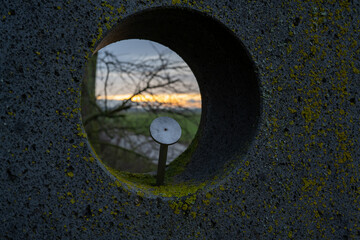 A small hole in a concrete wall with a metal object inside