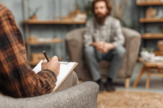 Counselor and Client in a Therapy Session Indoors at a Quiet Location During the Day Engaging in Conversation and Reflection