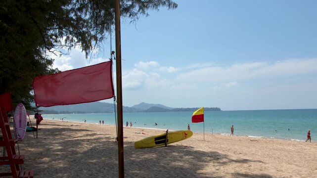 Red Warning Flag Blowing on Tropical Beach in Phuket Thailand