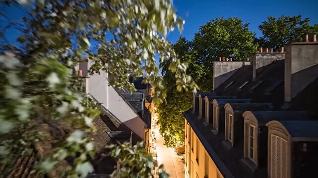 Rooftops and a narrow street illuminated at night in an old European city