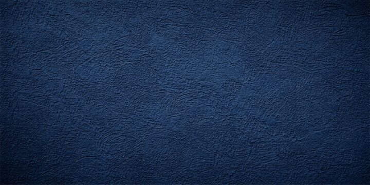 A closeup of a dark indigo denim fabric material with a rough blue leather texture and a textured cotton canvas pattern for a fashion clothing background