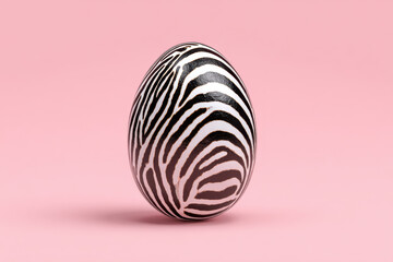 Zebra Striped Egg Placed on a Pastel Pink Background in a Minimal Setting