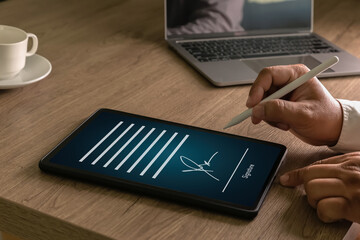 Businessman Electronic Signing document on a tablet with a stylus laptop representing secure e signature, contract approval, signs and paperless workflow.