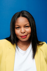 Confident businesswoman smiling on blue background