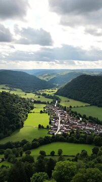 A charming village nestled in a lush green valley under a cloudy sky