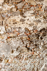 Decaying stone and brick walls of a pedestrian underpass underneath a road in Genoa, Italy