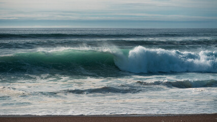 Obraz premium waves breaking on the beach