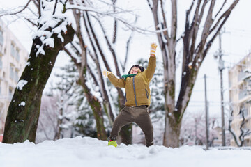 雪の公園で遊ぶ6歳の男の子