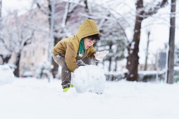 雪の公園で遊ぶ6歳の男の子