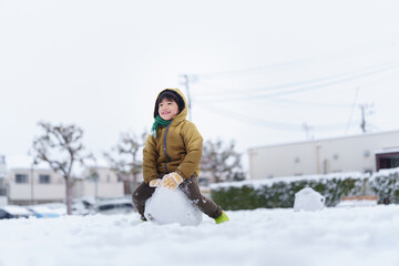 雪の公園で遊ぶ6歳の男の子