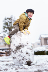 雪の公園で遊ぶ6歳の男の子