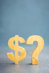 Dollar sign and question mark on grey stone surface, representing financial uncertainty, investment...