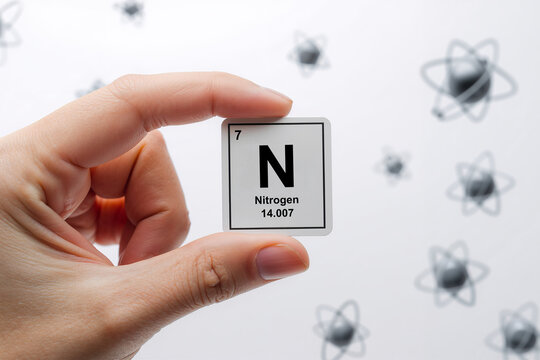 Nitrogen element symbol handheld and atoms floating in background