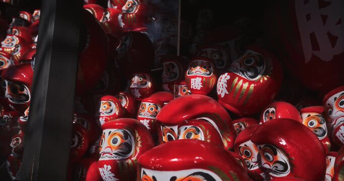 Closeup steady cam shot on large cluster of daruma dolls