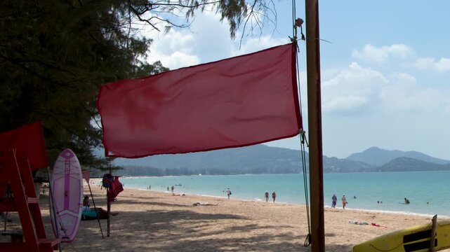 Red Warning Flag Blowing in the Wind on Phuket Tropical Beach