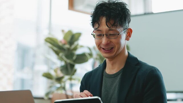 ノートパソコンとタブレットを使いながら打ち合わせをする日本人ビジネスマン, Japanese businessman discussing while using a laptop and tablet