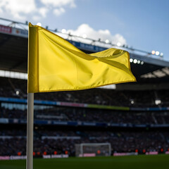 A yellow flag waving prominently in front of a blurred stadium