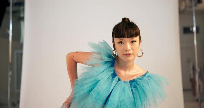 BTS, face and photoshoot with Asian woman on set for clothing magazine or fashion publication. Art, catalog and style with confident model in studio for creative session or photography production