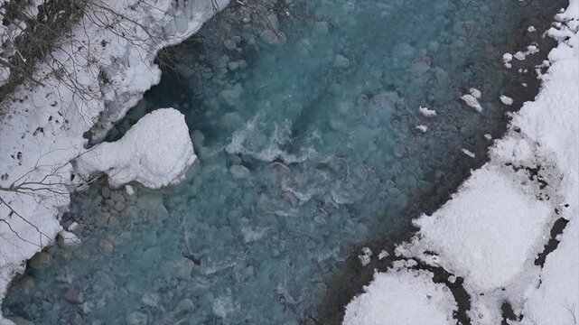 Top-Down Aerial View of Cobalt Blue Biei River Flowing Through Snow and Ice in Winter, Hokkaido Japan